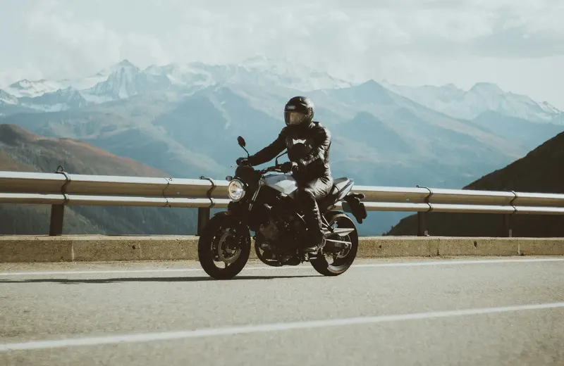 Dağ yolunda motosikletli; temsilî yolculuk görseli